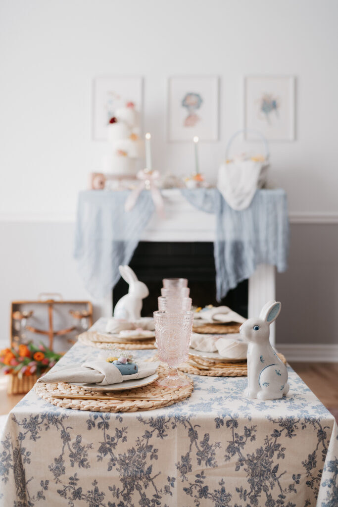 indoor picnic setup with bunnies, vintage blue flower tablecloth, pink glasses and coffee table