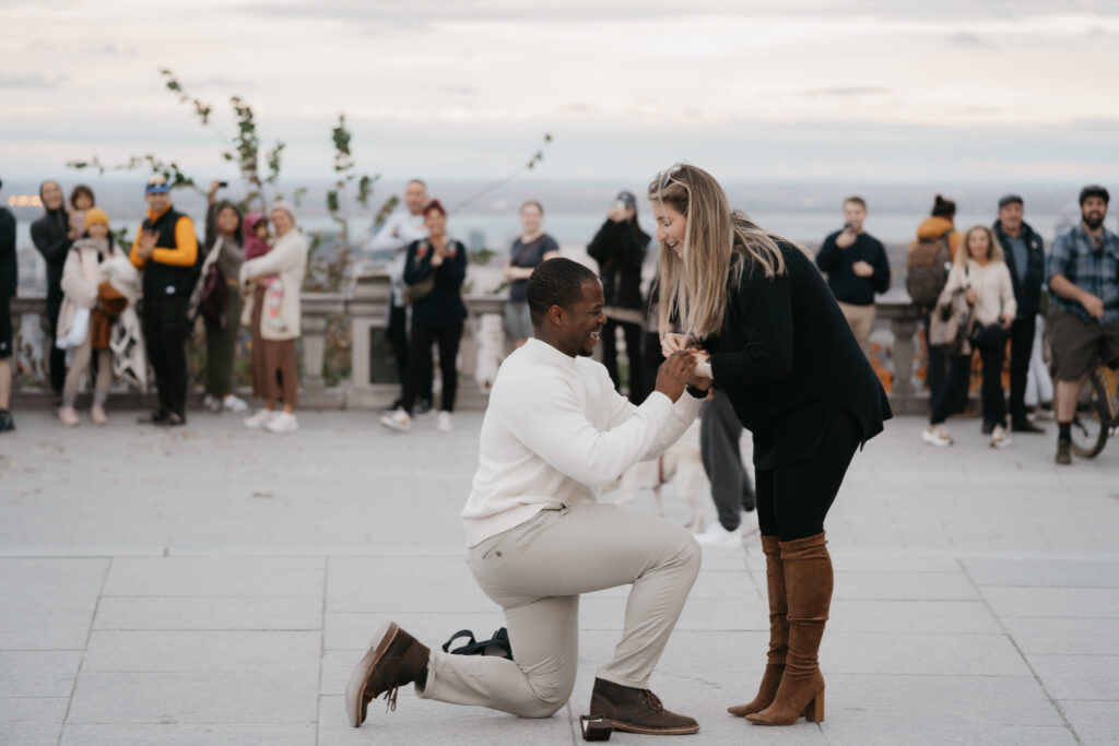 a man is getting on his knew to propose to his girl friend at the Mont Royal