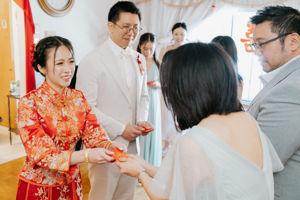 Bride receiving a red envelope during tea ceremony 