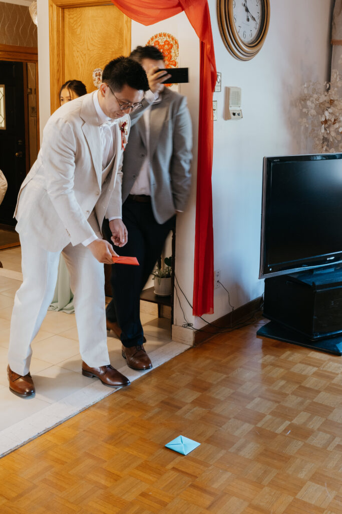 Groom playing ddkaji game during a chinese wedding in Montreal