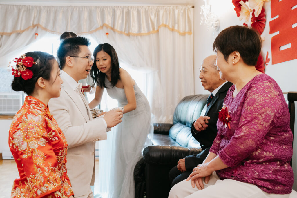 The chinese groom is serving the tea to his now father in law during the tea ceremony